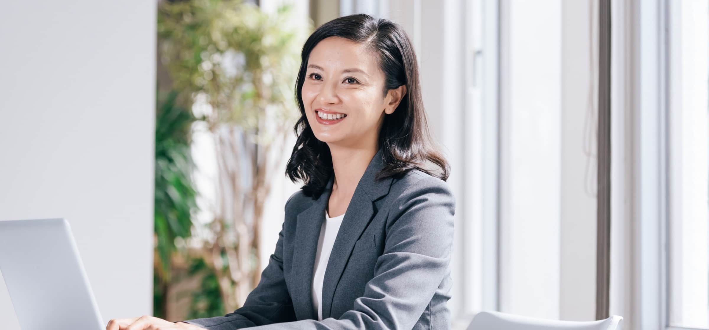 笑顔で正面を向くスーツの女性