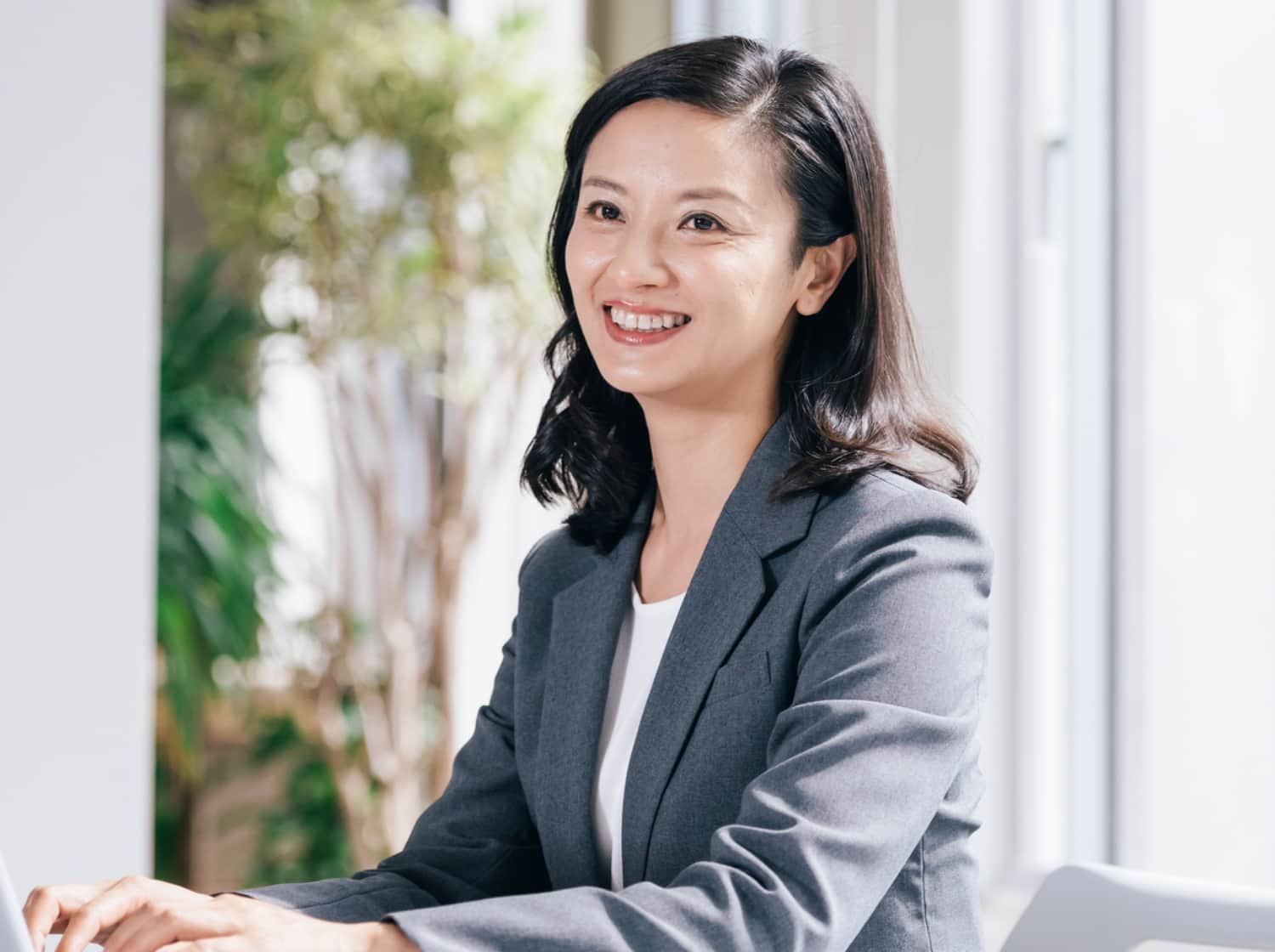 笑顔で正面を向くスーツの女性